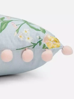 Kwadratowa poduszka z pomponami i kwiatowym wzorem